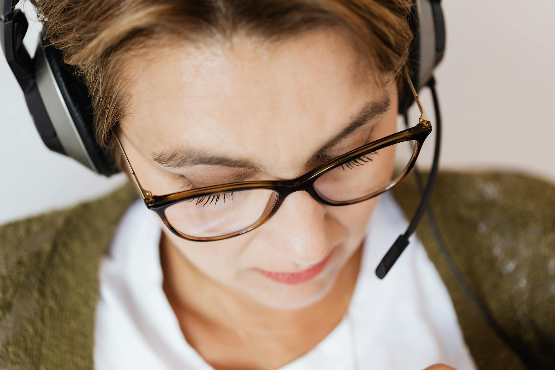 Kobieta w słuchawkach pracuje przy komputerze, skupiona na zadaniu