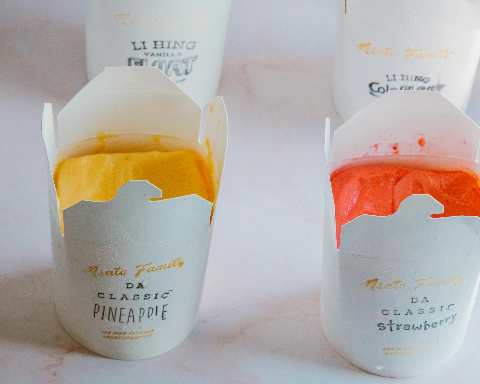 Lody o smaku ananasa i truskawki w kolorowych firmowych opakowaniach