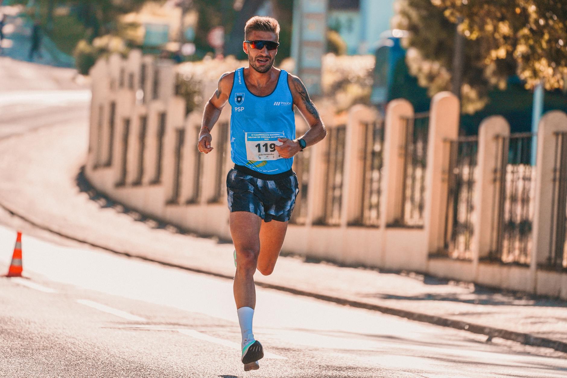 Biegacz amator biegnący w miejskim maratonie w słoneczny dzień