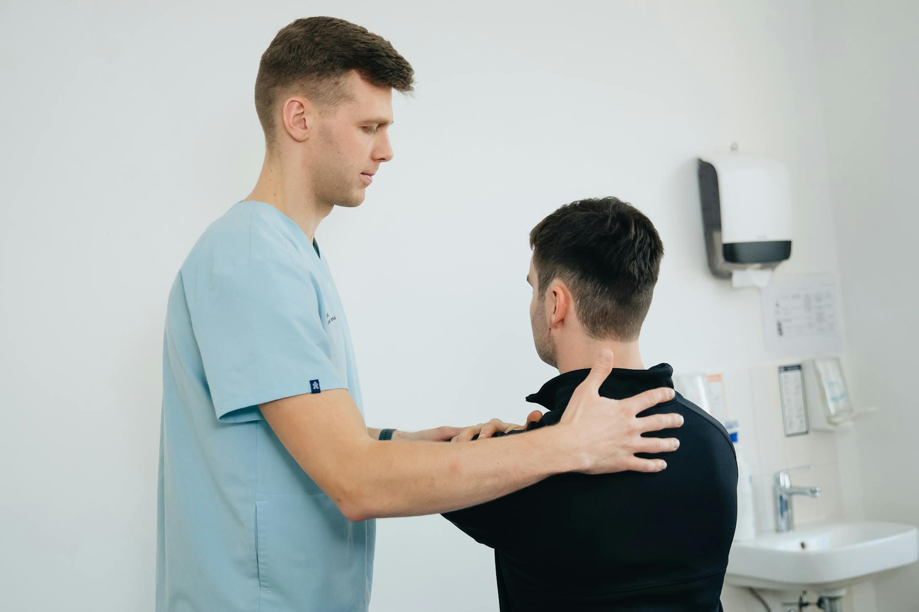 Fizjoterapeuta ćwiczy bark pacjenta podczas terapii bólu łokcia