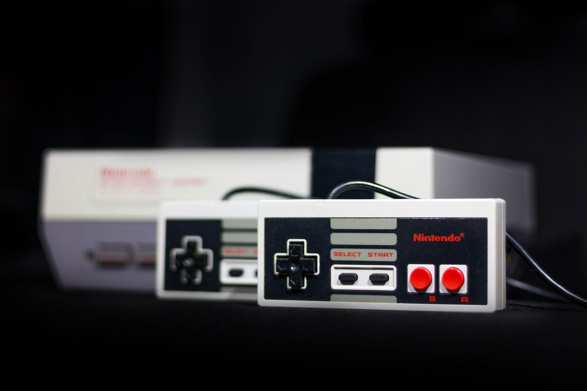 Zbliżenie na klasyczną konsolę Nintendo i dwa retro kontrolery