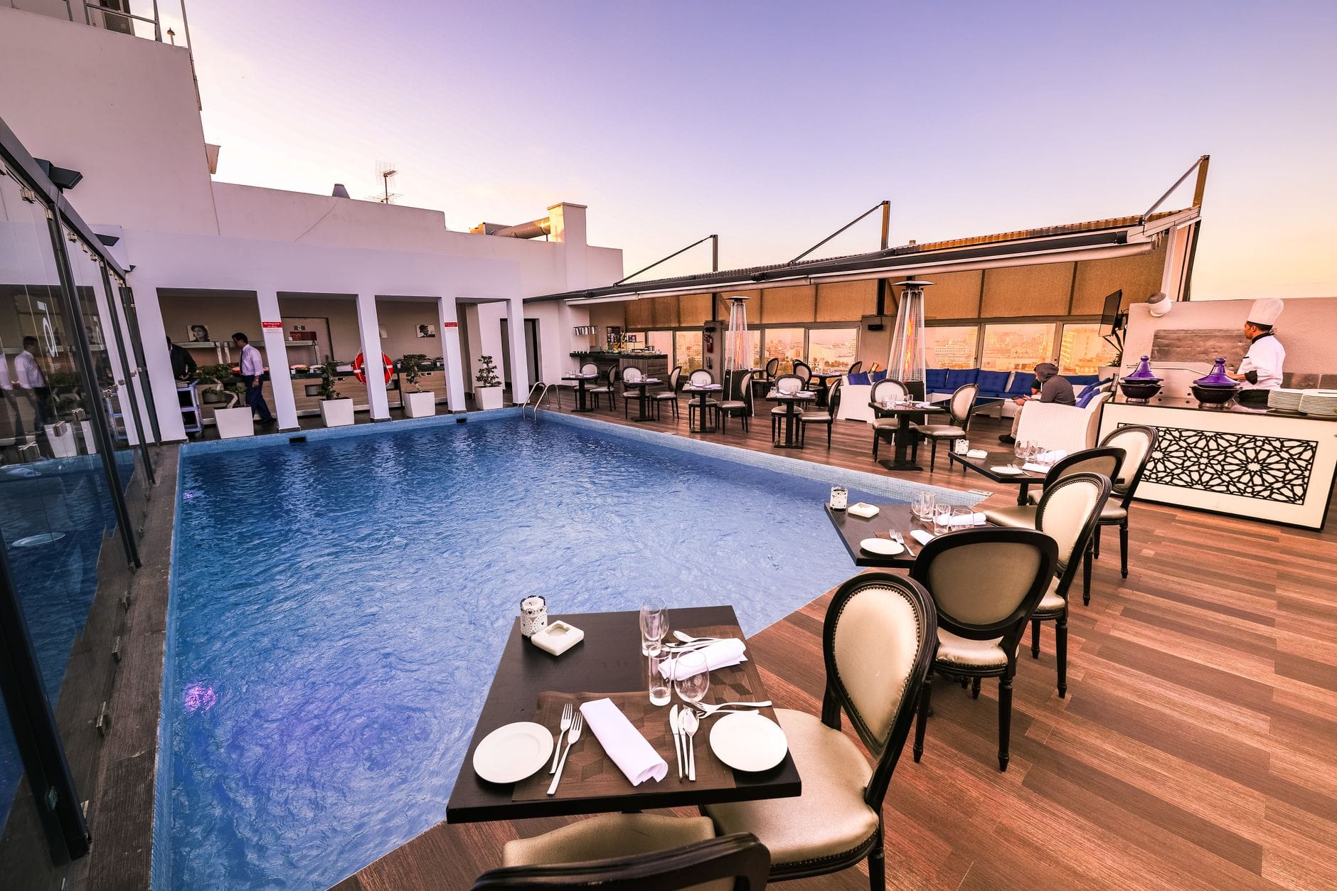 Elegancka restauracja na dachu z basenem o zachodzie słońca