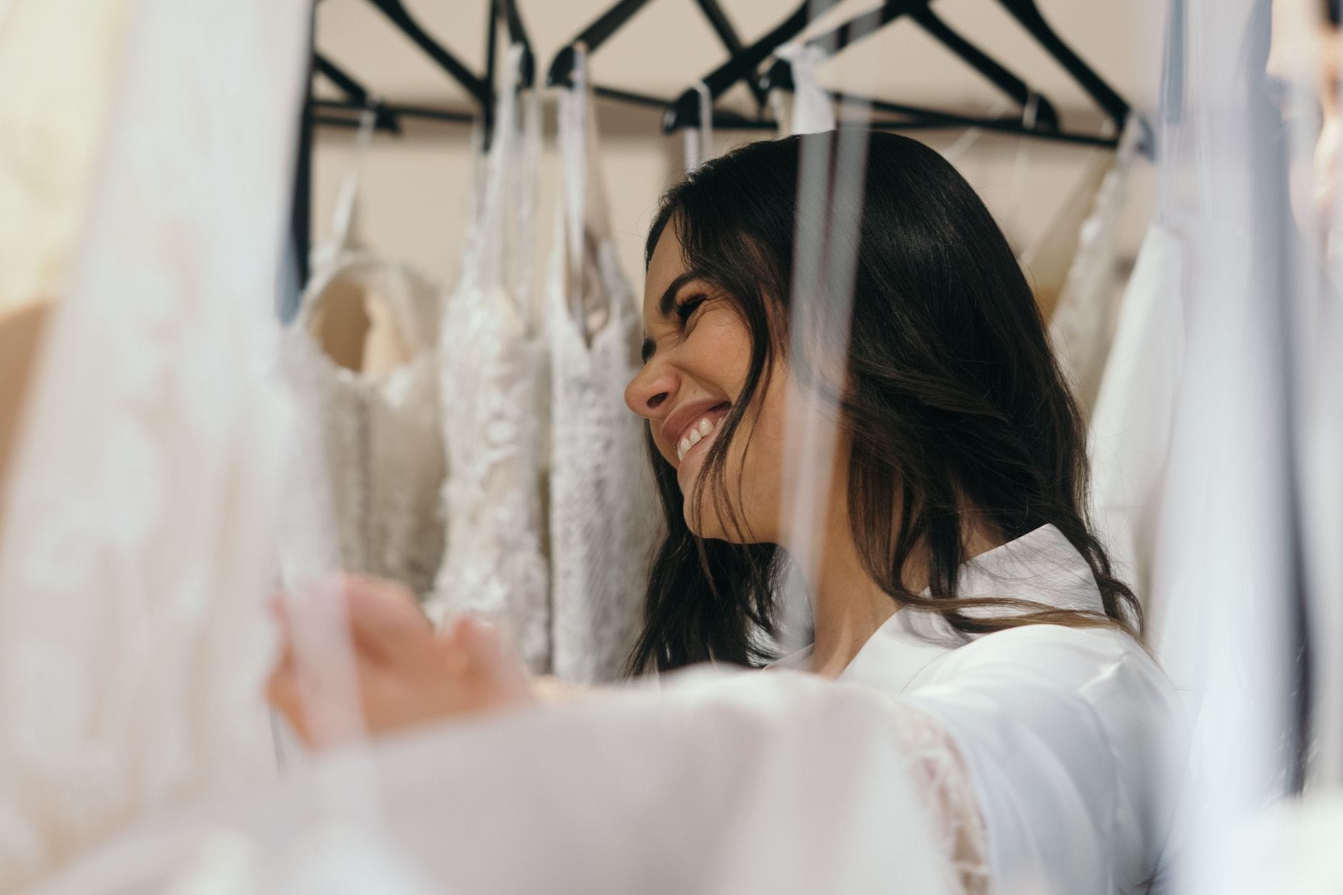 Uśmiechnięta panna młoda mierzy suknię ślubną w salonie bridal Uśmiechnięta panna młoda mierzy suknię ślubną w salonie bridal